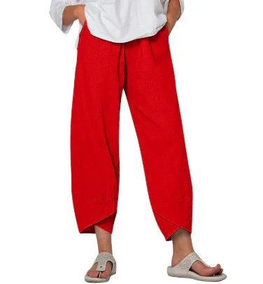 Woman wearing loose fit red cropped pants with asymmetrical hemlines and white top