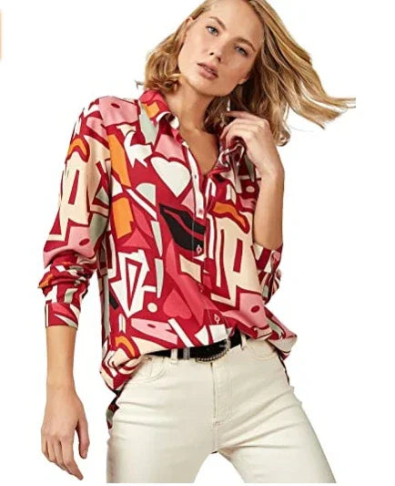 Woman wearing a colorful abstract print long-sleeve blouse paired with off-white pants