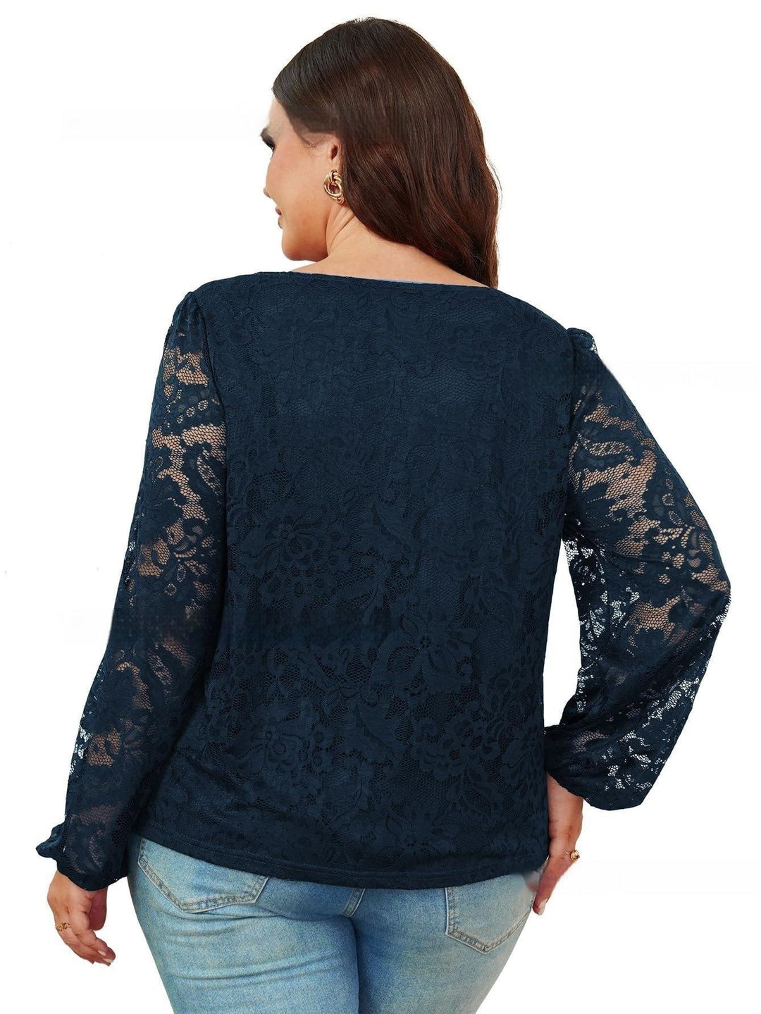 Plus size woman wearing navy blue floral lace long sleeve top with light blue jeans, back view