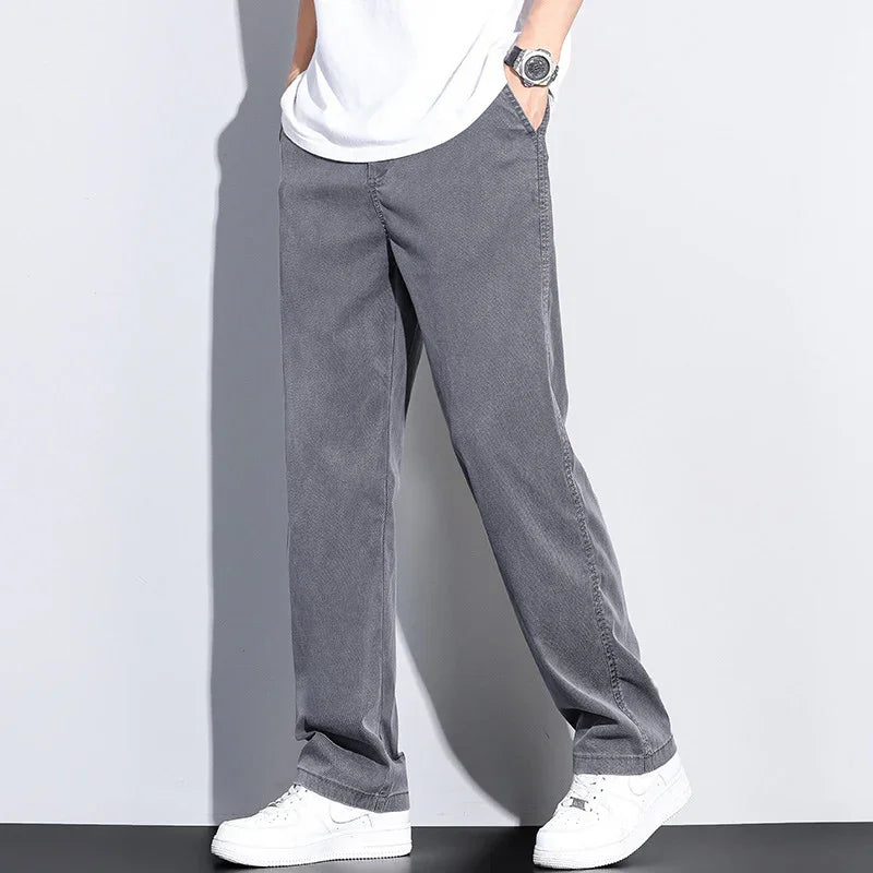 Man wearing casual gray wide-leg pants with white sneakers and a white t-shirt