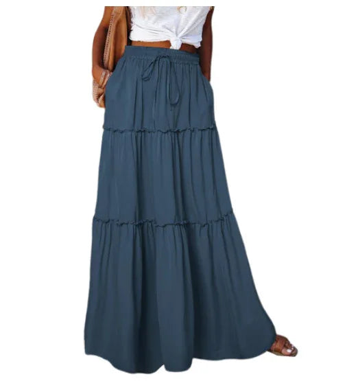 woman wearing a dark blue tiered maxi skirt with drawstring waist and white knotted top