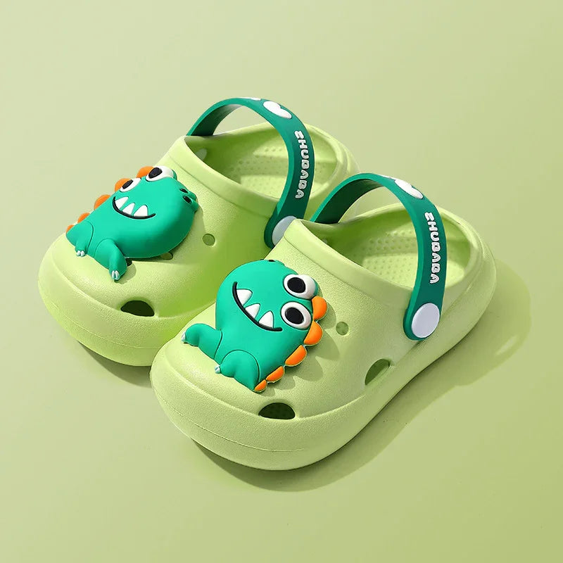Light green kids clogs with green dinosaur decoration and adjustable straps on green background