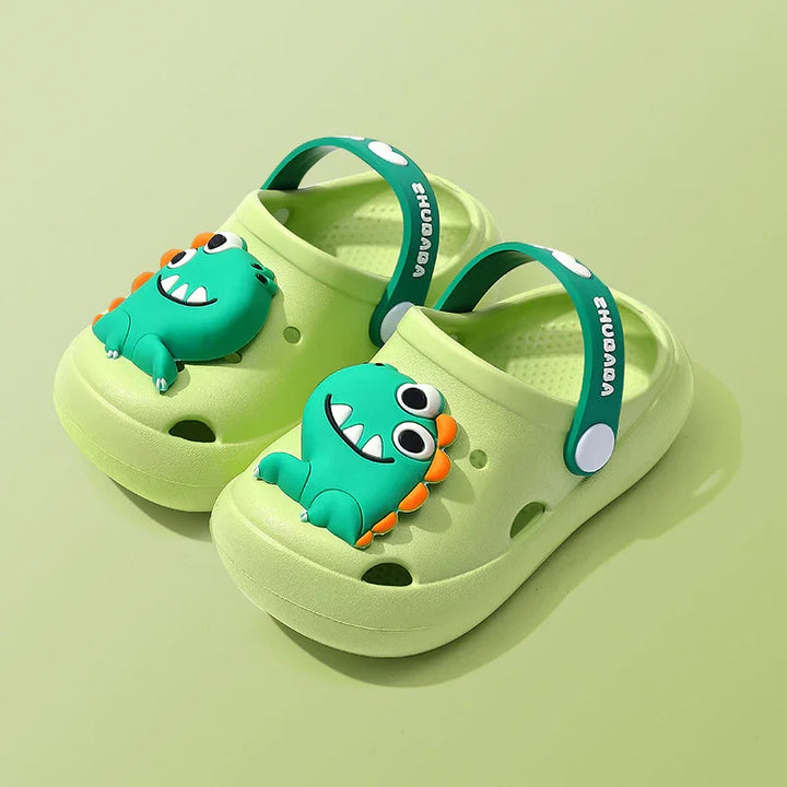 Light green kids clogs with green dinosaur decoration and adjustable straps on green background