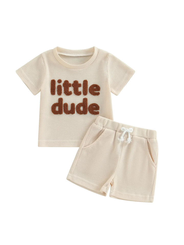 Beige toddler outfit with short sleeve top reading little dude and matching shorts with drawstring
