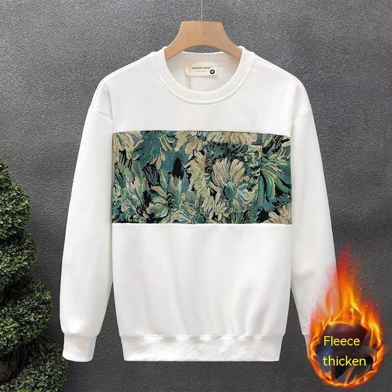 White fleece sweatshirt with a green and beige floral tapestry panel on front, hanging on wooden hanger