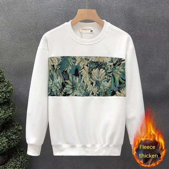 White fleece sweatshirt with a green and beige floral tapestry panel on front, hanging on wooden hanger