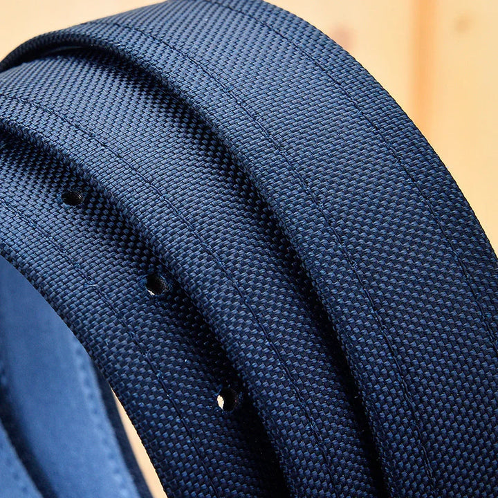 Close-up of navy blue woven fabric belt with stitched details and adjustment holes on wooden background