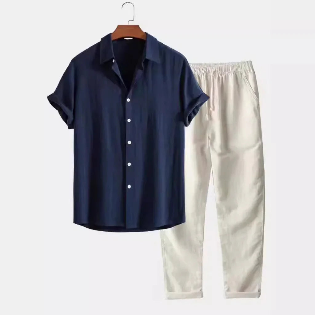 Navy blue short-sleeve button-up shirt with white buttons and beige elastic waist pants set on white background