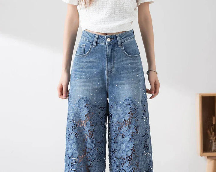 Woman wearing high-waisted blue denim jeans with floral lace cutout design and rhinestone details
