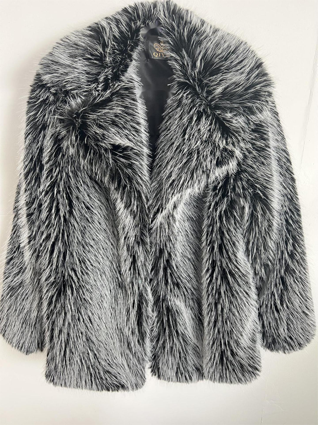 Black and white faux fur women's coat with thick texture on a white background