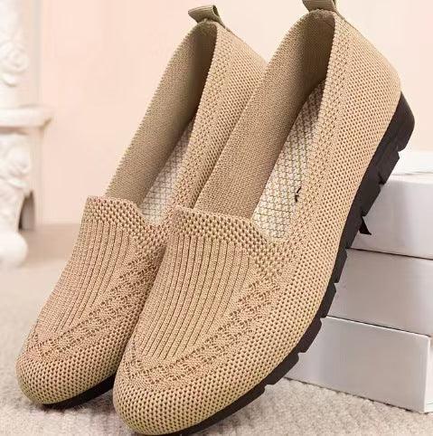 Beige knitted slip-on flat shoes with black rubber sole on white box