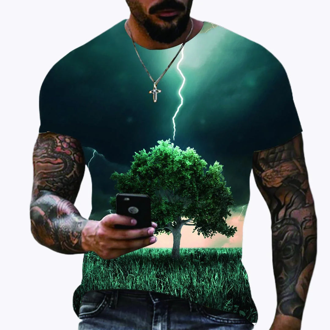 Man wearing tattooed sleeves and necklace with a t-shirt featuring a tree, grass, and lightning storm
