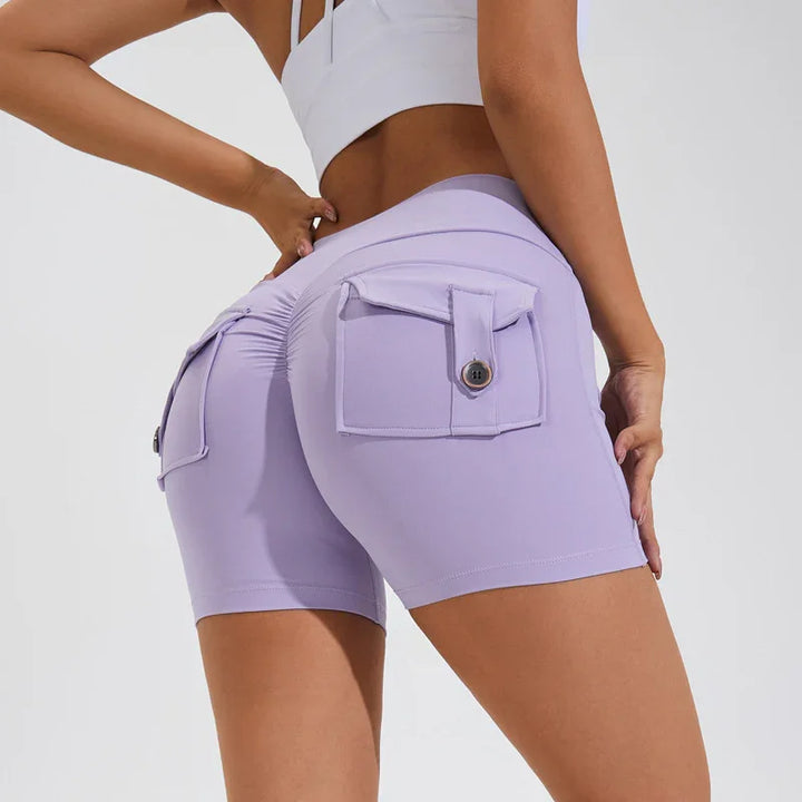 Woman wearing high-waisted lavender bike shorts with buttoned back pockets and ruched detail