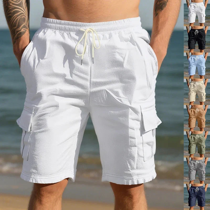 Close-up of man wearing white casual cargo shorts with drawstring by the beach, showing multiple color options on side