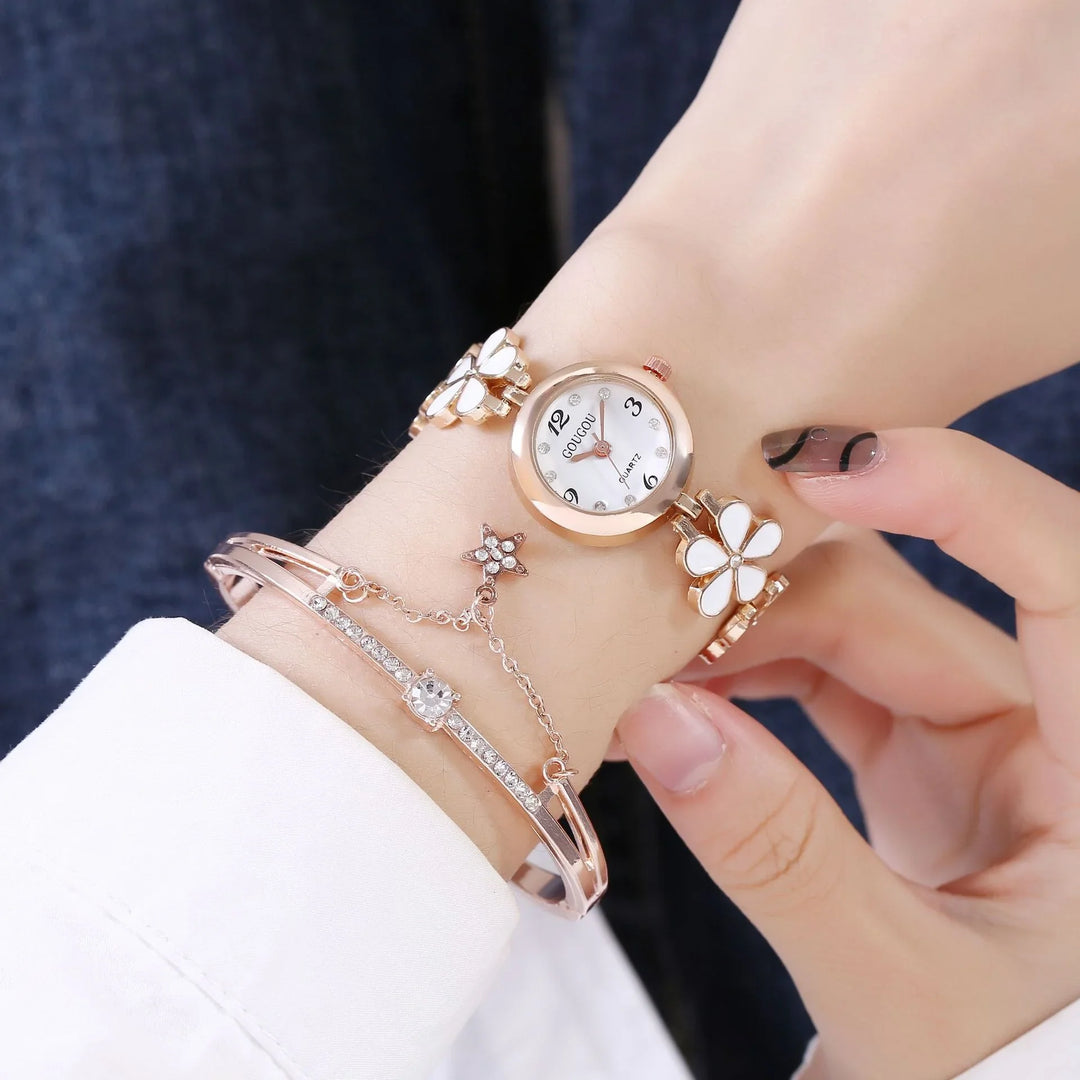 Wrist with rose gold butterfly watch and crystal-studded bracelet on a person's hand