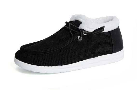 Black casual slip-on shoe with white fur lining and white sole on white background