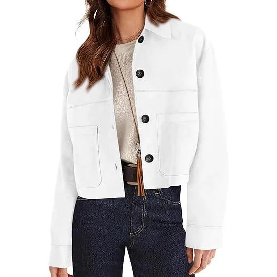 woman wearing white button-up jacket with large pockets, beige top, and dark jeans
