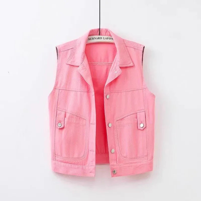 Pink sleeveless denim vest with collar and button closure hanging on white background