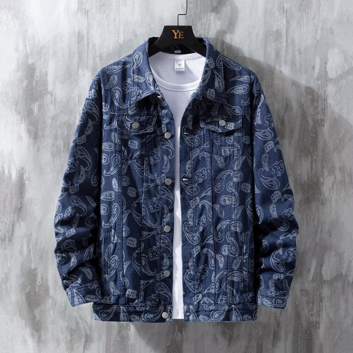Blue denim jacket with paisley print over white t-shirt on black hanger against gray wall