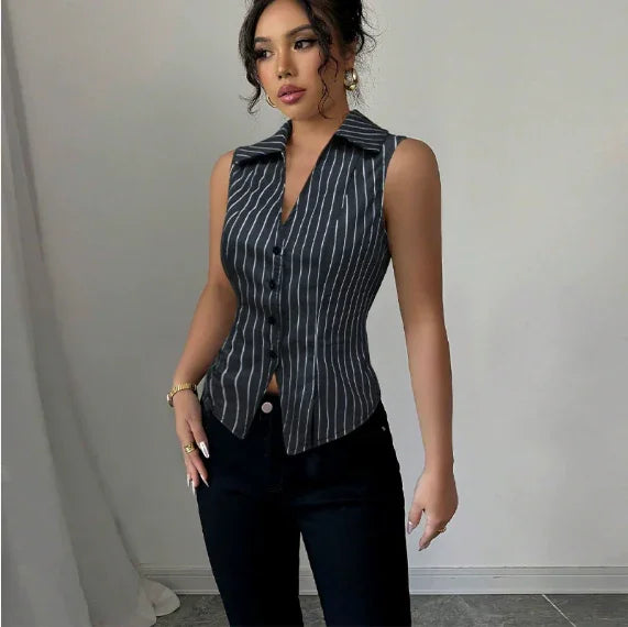 Woman wearing sleeveless black pinstripe button-up blouse paired with black pants against plain background
