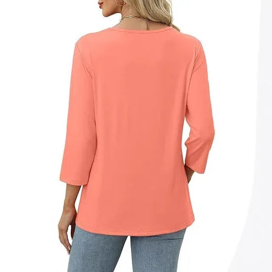Woman wearing coral pink long-sleeve blouse with round neckline and light blue jeans, back view
