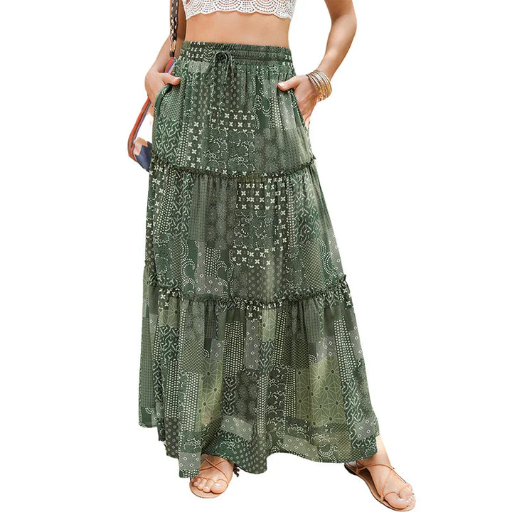 Green bohemian tiered maxi skirt with patchwork print, worn with sandals and crop top