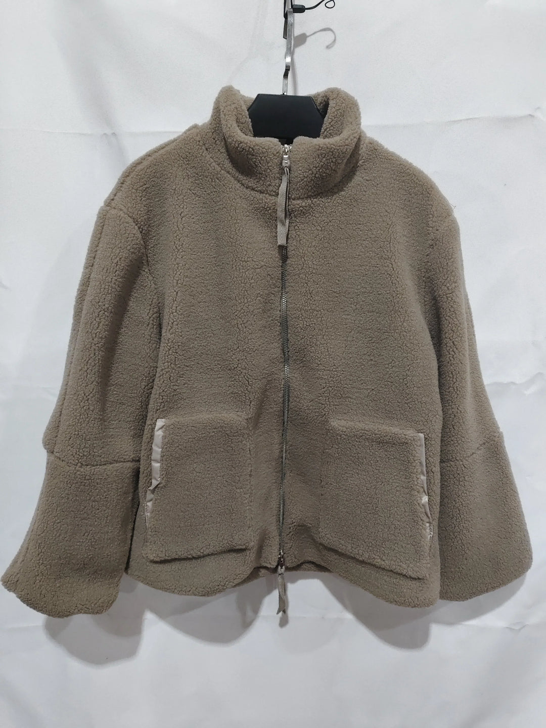 Beige fleece jacket with full zipper and front pockets hanging on hanger
