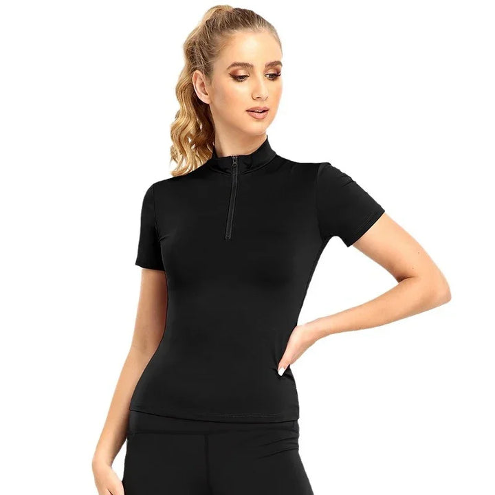 Woman wearing fitted black short-sleeve zip-up athletic top with high collar