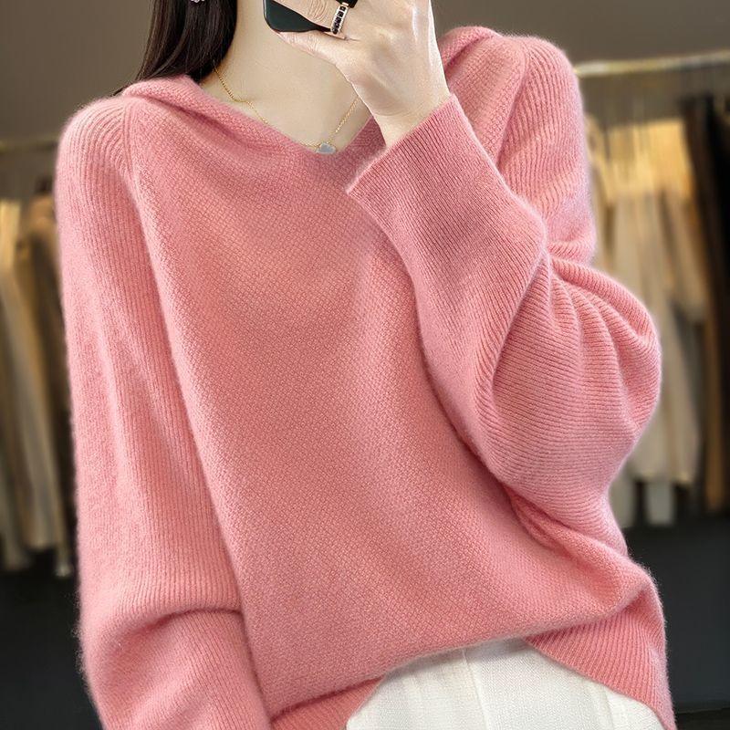 Woman wearing a soft pink knitted sweater with balloon sleeves and a V-neck, paired with white pants