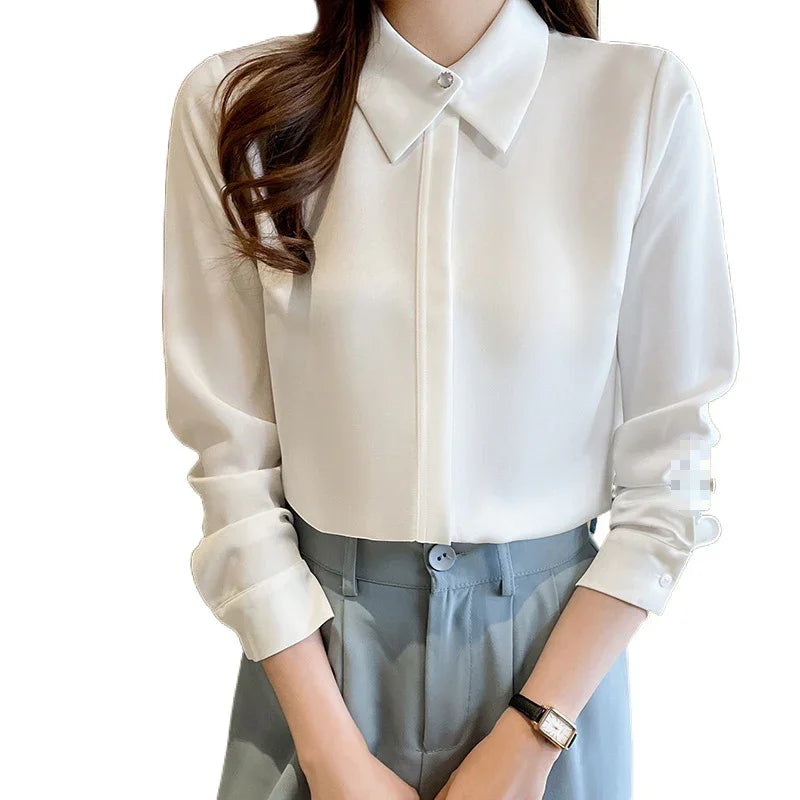 Woman wearing white long-sleeve button-up blouse with a pointed collar and light blue high-waisted trousers