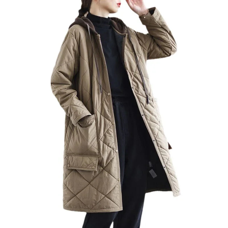 Woman wearing long quilted beige coat with hood and large front pockets over black outfit