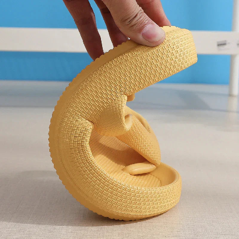 Hand bending a flexible yellow textured shoe sole against a blue and beige background