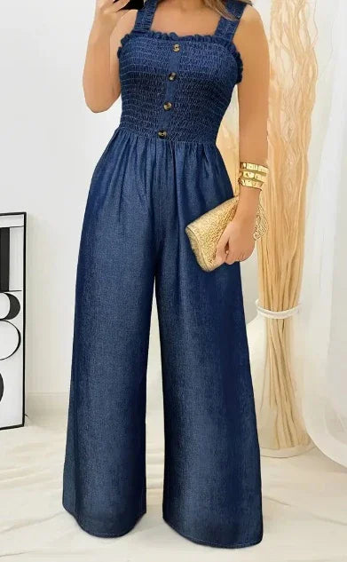 woman wearing navy blue sleeveless wide-leg jumpsuit with button front holding gold clutch