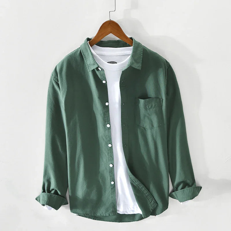 Green button-up shirt with rolled sleeves layered over white T-shirt on wooden hanger