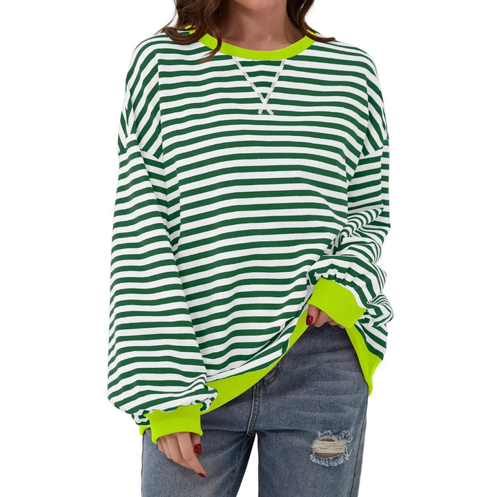 Woman wearing green and white striped long sleeve sweatshirt with neon yellow cuffs and neckline