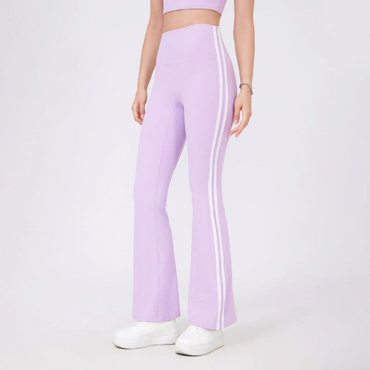 Woman wearing lilac high-waisted flared leggings with white side stripes and white sneakers