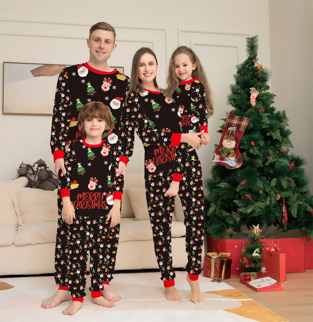 Happy family of four in matching Christmas pajamas with Santa and reindeer prints near decorated Christmas tree
