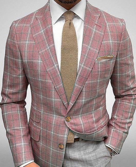 man wearing a pink plaid blazer with beige tie, white shirt, and gray trousers