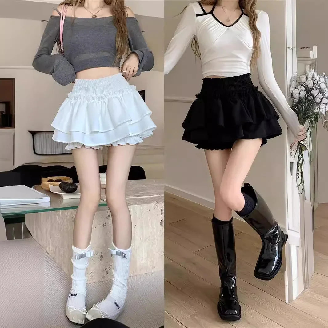 Two women modeling ruffled mini skirts with long sleeve crop tops and stylish footwear indoors