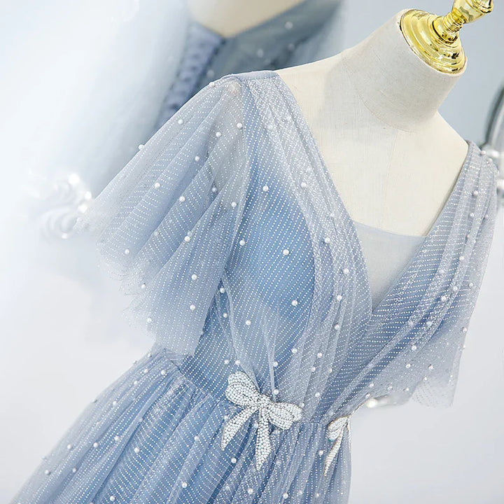 Elegant light blue mesh dress with pearl beads and rhinestone bow on mannequin