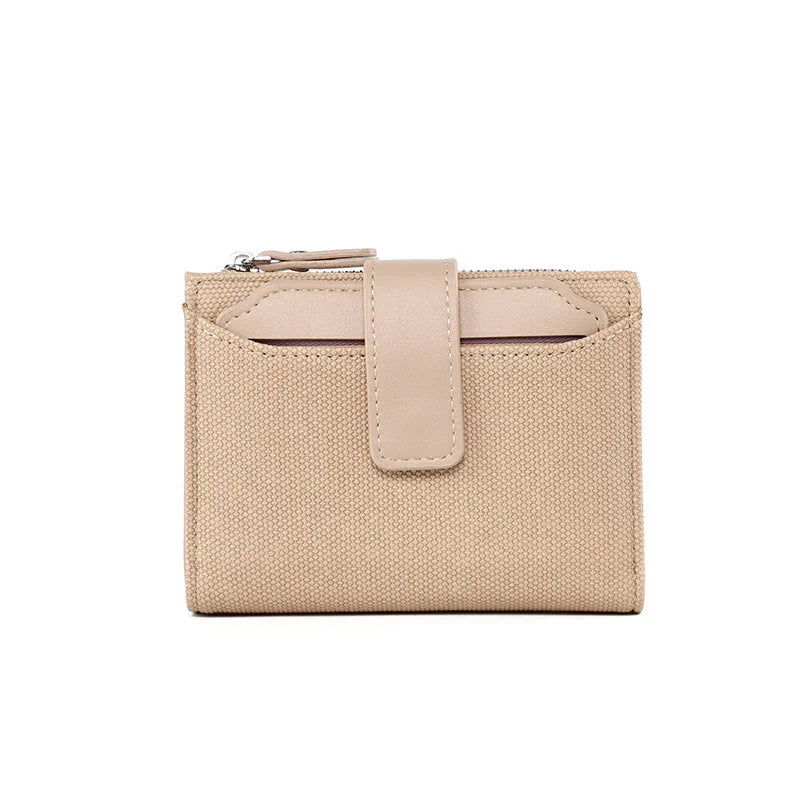 Beige canvas and leather compact wallet with zipper and snap closure on white background