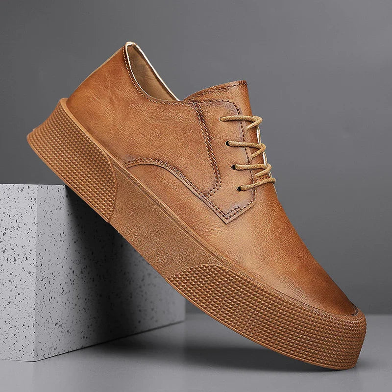Brown leather casual shoe with thick textured sole displayed on grey concrete block