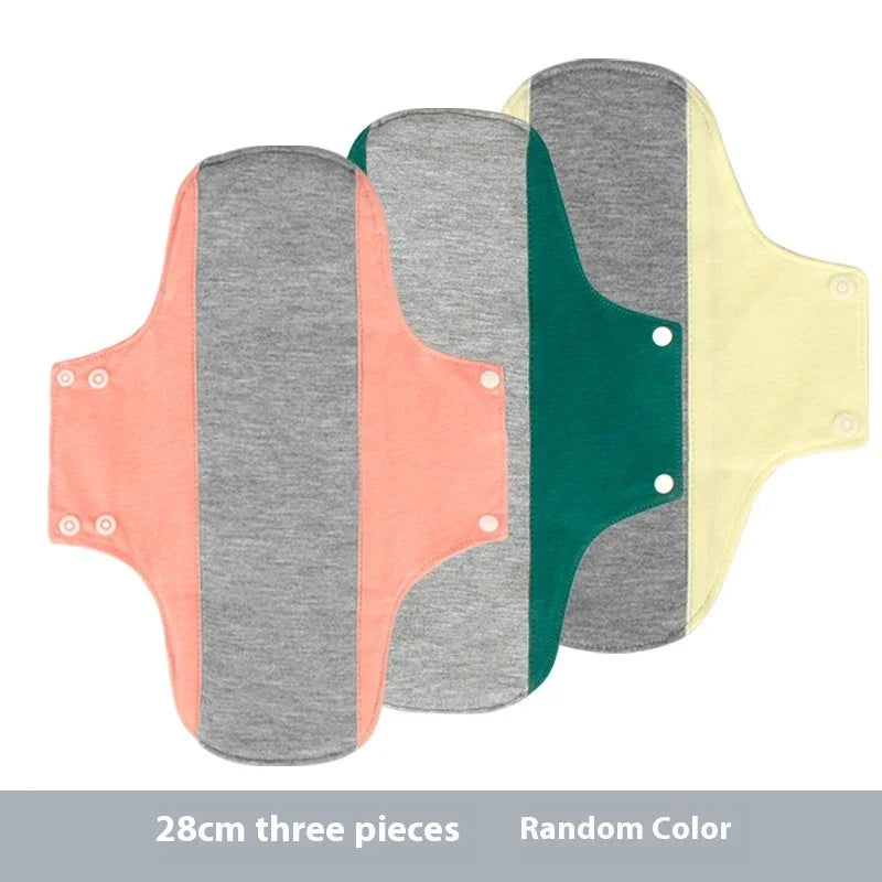 Set of three 28cm reusable cloth menstrual pads in pink, green, and yellow with grey center and snap buttons