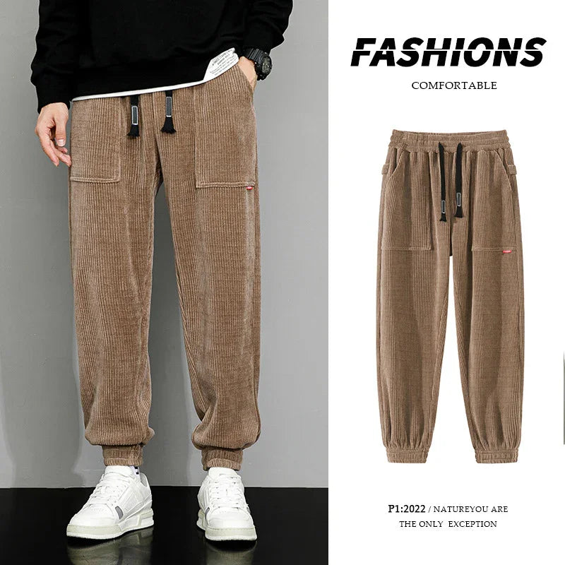 Brown corduroy jogger pants with elastic cuffs and drawstring, styled with white sneakers