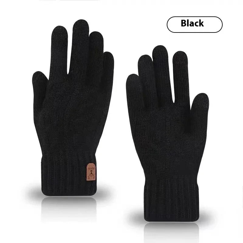 Pair of black knit winter gloves with ribbed cuffs and small brown tag on white background