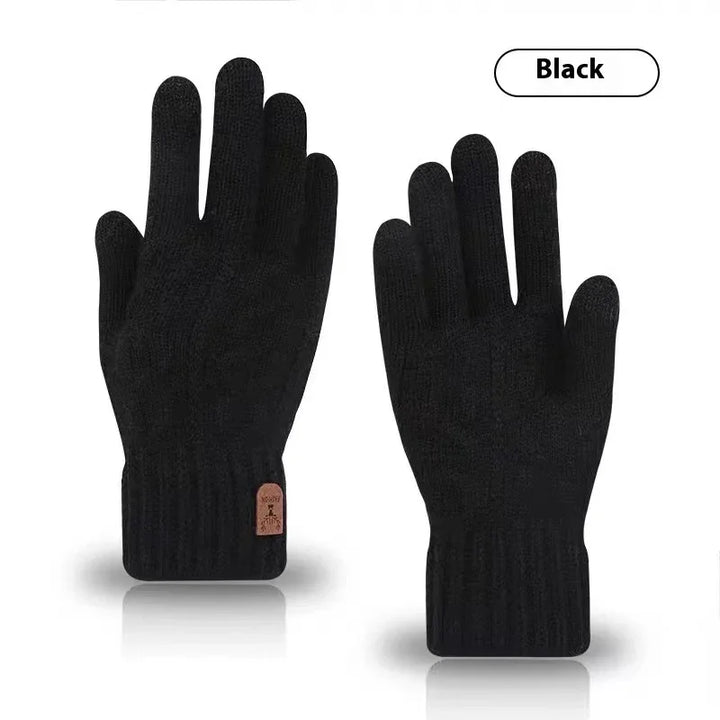 Pair of black knit winter gloves with ribbed cuffs and small brown tag on white background