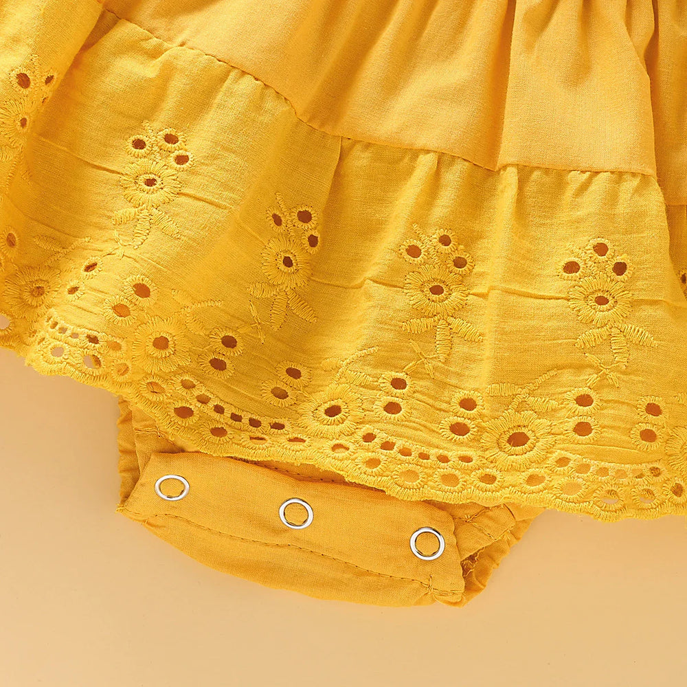 Yellow baby romper dress with eyelet embroidery and snap button closure