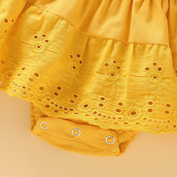 Yellow baby romper dress with eyelet embroidery and snap button closure