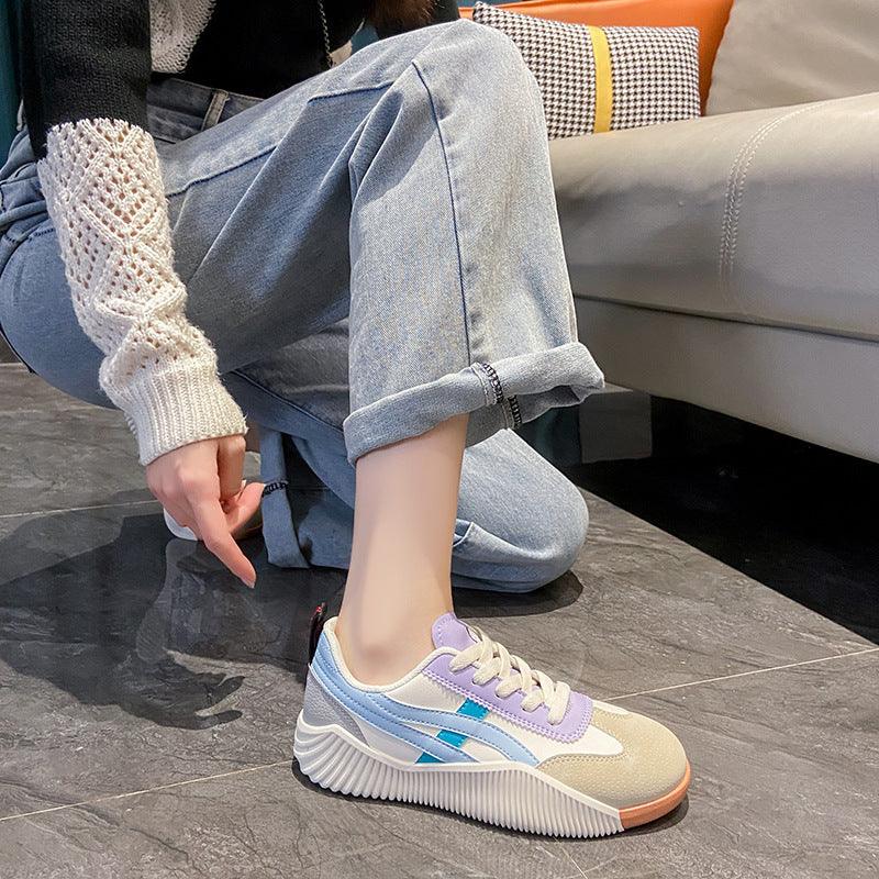casual pastel color sneakers with blue and purple accents worn with rolled light blue jeans indoors