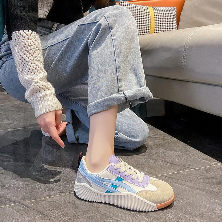 casual pastel color sneakers with blue and purple accents worn with rolled light blue jeans indoors